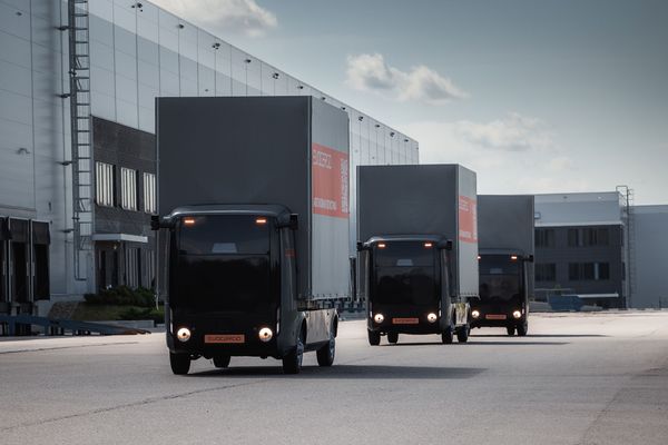 Автономные электрогрузовики Evocargo N1 в колонне на территории логистического комплекса Fplus в Подмосковье.