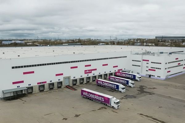 Логистический центр с грузовиками e-commerce-компании у ворот отгрузки — вид с высоты, демонстрирующий масштабы складской инфраструктуры перед сезоном пикового спроса