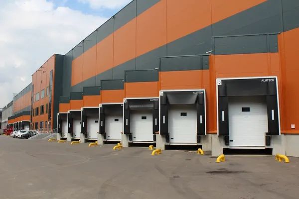 Современный склад JAC в индустриальном парке «Андреевское» с зоной погрузки и фасадом серо-жёлтого цвета
