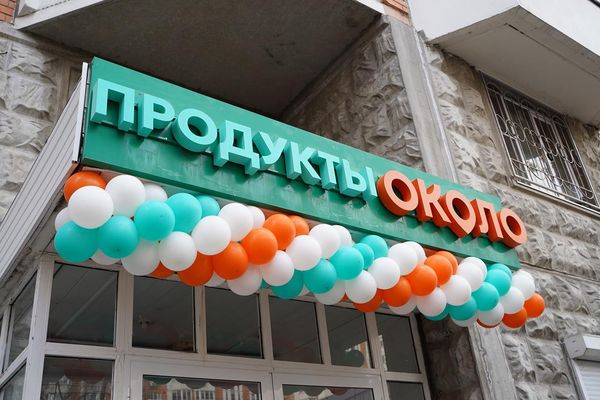 Фасад магазина под брендом «ОКОЛО» с фирменной вывеской и праздничным оформлением у входа
