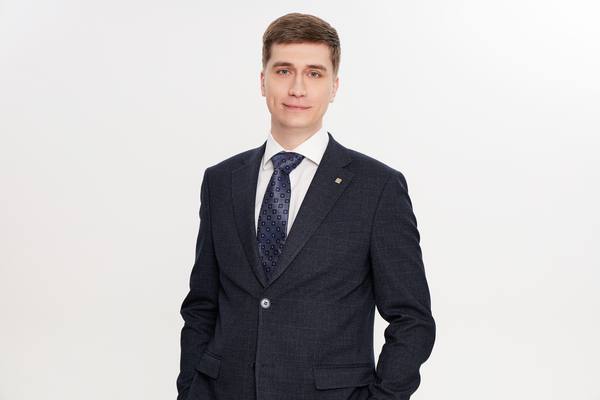 Илья Черкасов, директор департамента индустриально-складской недвижимости Bright Rich в Москве, портрет в деловом костюме на белом фоне.