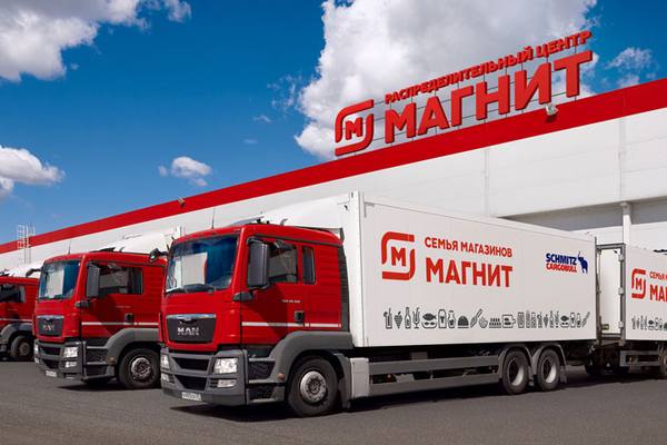 Грузовики логистической службы сети «Магнит» на фоне распределительного центра компании