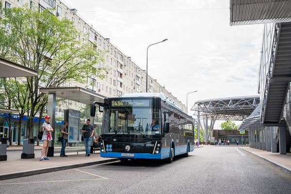 Автобус Московского транспорта у остановки рядом с транспортно-пересадочным узлом; пригородный маршрут к метро/МЦД, пассажиры ждут посадку