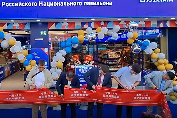 Открытие магазина «Сделано в России» в Шанхае: представители разрезают красную ленту у входа Российского Национального павильона, виден фасад и торговый зал