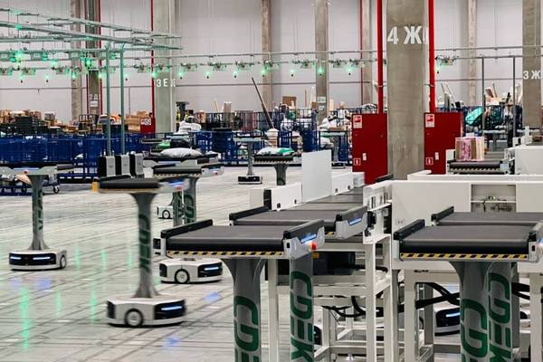 Роботизированная зона нового сортировочного центра СДЭК в Екатеринбурге с конвейерными линиями и автоматическими тележками