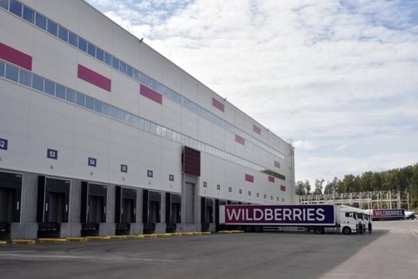 Логистический склад Wildberries с погрузочными доками и грузовиками у рампы в Красноярске — распределительный центр для ускорения доставки по Сибири