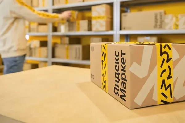 Упаковка Яндекс Маркета на складе с фирменной жёлтой лентой и логотипом