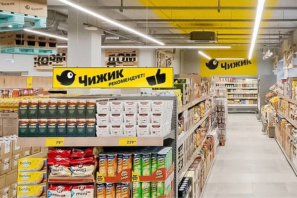 Интерьер магазина «Чижик» с полками товаров и фирменной навигацией