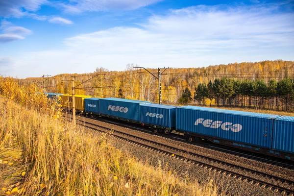 Контейнерный поезд FESCO на железной дороге в осеннем пейзаже по маршруту Владивосток — Екатеринбург