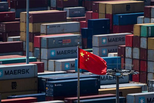 Контейнерный терминал в Китае с флагом КНР на фоне грузов Maersk и других операторов, символизирующий снижение логистической активности в период Золотой недели 2025 года