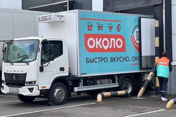 Рефрижераторный грузовик с брендом «ОКОЛО» на разгрузке у распределительного центра в Подмосковье
