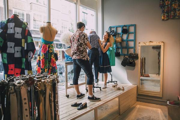 Молодые дизайнеры в региональном fashion-магазине работают над оформлением витрины и подбором образов для манекенов