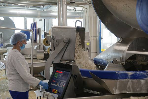 Сотрудник предприятия Unifrost контролирует автоматическую линию переработки рыбы и производства сурими в цехе пищевой промышленности