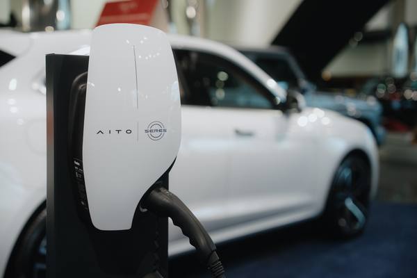 Зарядная станция AITO SERES Wall-E на фоне электромобиля в автосалоне