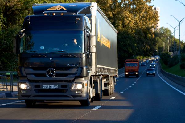 Грузовой автомобиль компании «Деловые Линии» на трассе во время международной перевозки промышленного оборудования