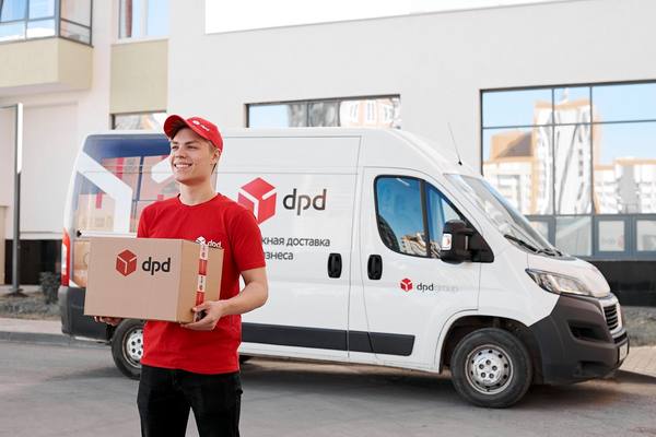 Курьер DPD с посылкой на фоне фирменного фургона у жилого дома — символ расширения сети пунктов выдачи и активной доставки в регионах России в 2025 году.