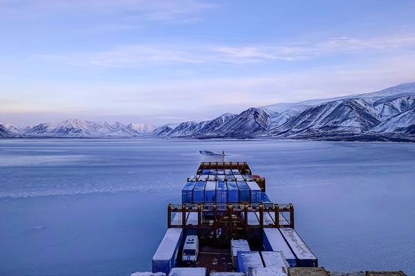 Контейнеровоз FESCO в ледовых водах на фоне заснеженных гор в Чукотском регионе