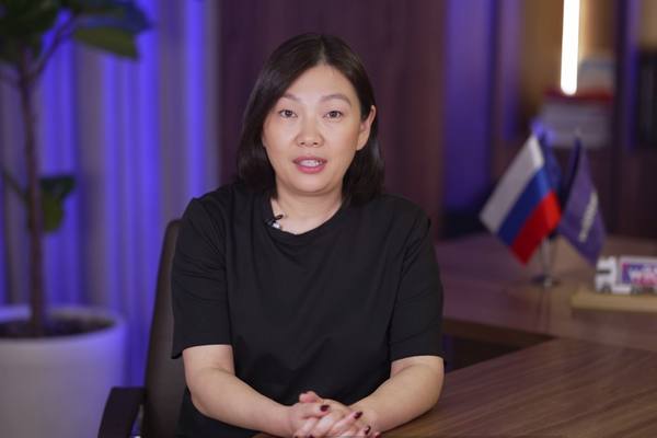 Татьяна Ким руководитель крупной цифровой платформы выступает в офисе на фоне российского флага