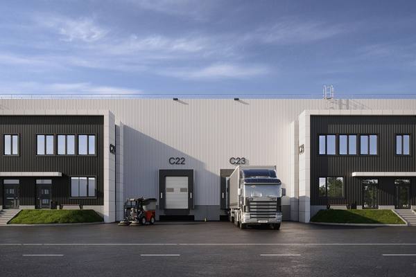 Фасад складского комплекса промпарка Токарево с доковыми воротами и грузовиком на разгрузке