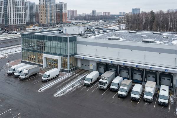 Городской складской комплекс с погрузочными доками и фургонами у рампы в России
