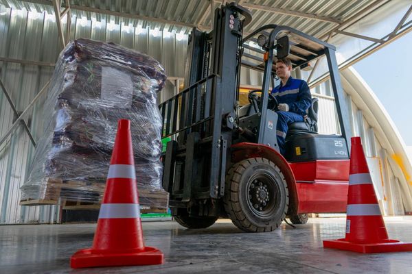 Работник агроагрегатора Х5 в Ярославской области перевозит погрузчиком паллет с упакованной продукцией в современном овощехранилище