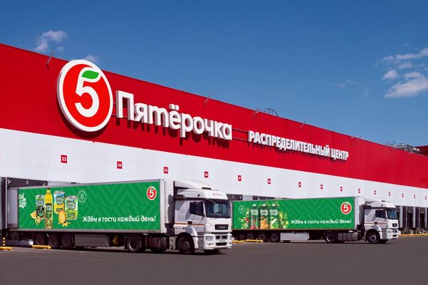 Фирменные грузовики X5 Group на фоне распределительного центра сети «Пятёрочка» — символ роста логистической инфраструктуры ритейлера