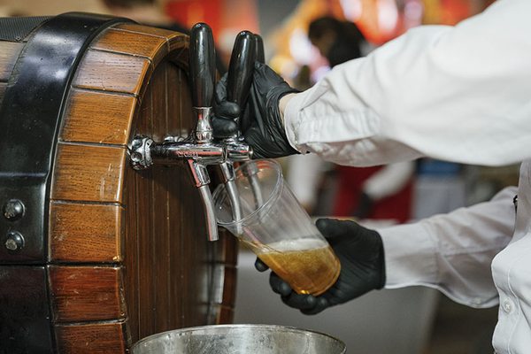 Налив пива из деревянной бочки на фестивале — иллюстрация развития ярмарок как нового канала сбыта и драйвера событийной логистики