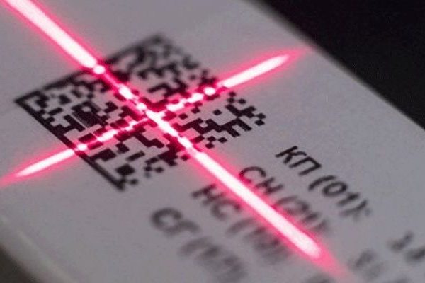 Сканирование DataMatrix-кода красным лазером на маркированной продукции, иллюстрирующее цифровой контроль и автоматизацию штрафов по системе «Честный знак»