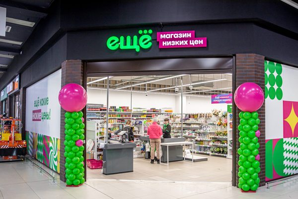 Вход в магазин низких цен «Ещё» с покупателями и праздничным оформлением входной группы