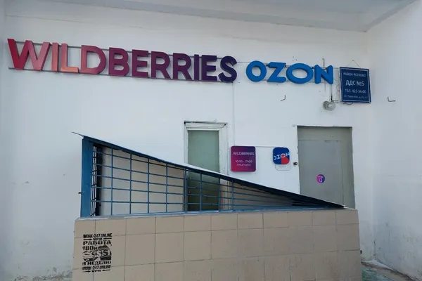 Фасад пункта выдачи заказов с вывесками нескольких маркетплейсов, отражающий мультибрендовый формат работы ПВЗ и изменения на рынке последней мили