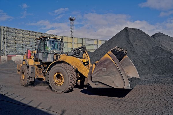 Фронтальный погрузчик перемещает угольную массу на территории Малого порта в Находке, демонстрируя процесс перевалки насыпных грузов