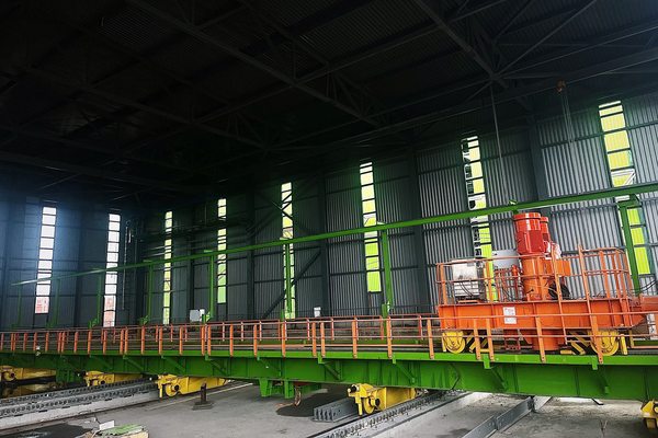 Передвижная платформа трансбордера на терминале Port Favor внутри производственного ангара; оборудование для перемещения вагонов на пути накопления.