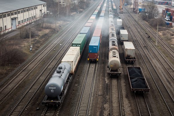 Грузовые поезда с контейнерами, цистернами и вагонами с углём на железнодорожной станции, отражающие изменение структуры погрузки на сети РЖД