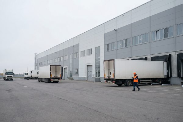 Грузовые автомобили у доков современного складского комплекса класса А в Санкт-Петербурге