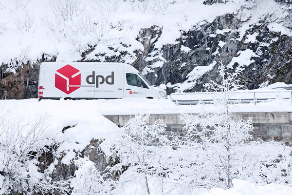 Курьерский автомобиль DPD зимой на загородной трассе — доставка посылок и подарков в сложных погодных условиях