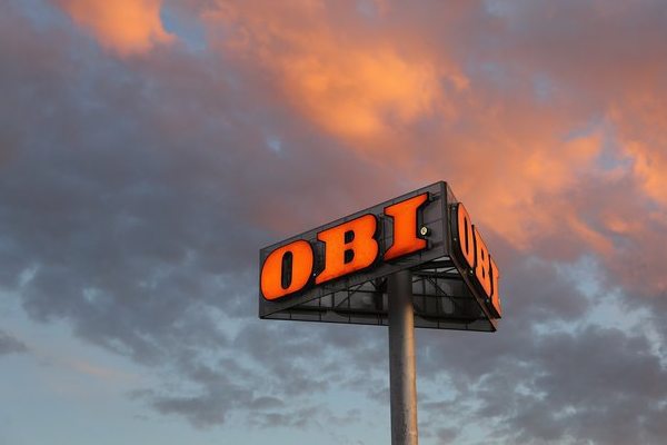 Вывеска строительного гипермаркета OBI на фоне неба как символ сделки по покупке сети компанией «Лента» и изменений на рынке DIY