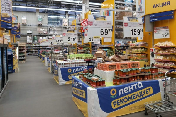 Торговый зал гипермаркета с промо-зонами и ценниками, иллюстрирующий анализ покупательского поведения и управление ассортиментом на основе данных