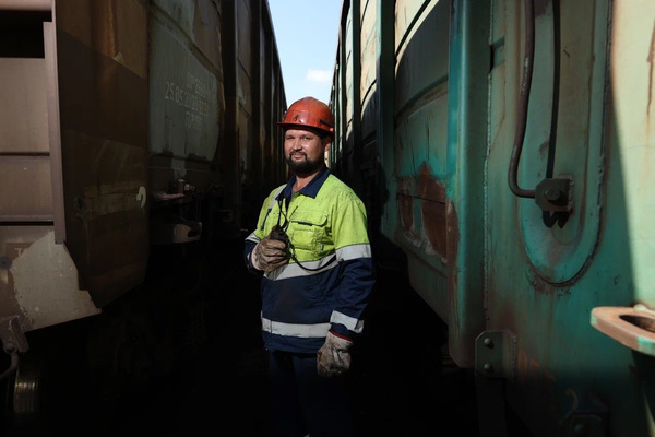 Работник порта между грузовыми вагонами — контроль состояния подвижного состава в Малом порту Находки