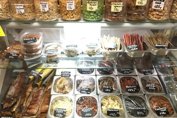 Витрина со снеками в российском магазине: рыбные закуски, орехи и семечки с ценниками, отражающие снижение импульсного спроса и изменение структуры потребления