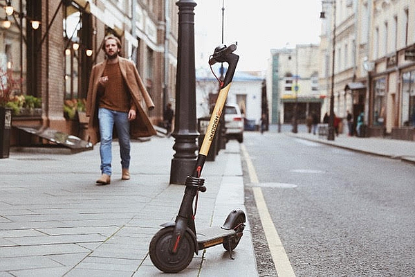 Электросамокат сервиса кикшеринга на городской улице — иллюстрация рынка микромобильности и изменения пользовательского спроса