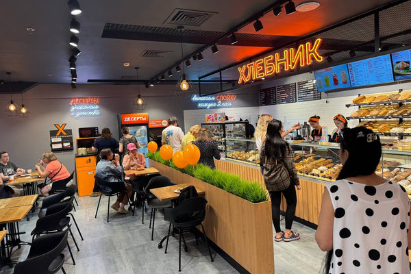 Интерьер кафе-пекарни с витриной выпечки и очередью покупателей как пример многоформатного развития сети HoReCa