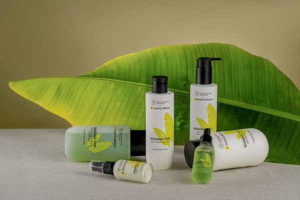 Линейка уходовой косметики Banana Trip от «Краснополянской косметики» и «Золотого Яблока» на фоне листа банана, иллюстрирующая коллаборацию локального бренда и бьюти-ритейлера
