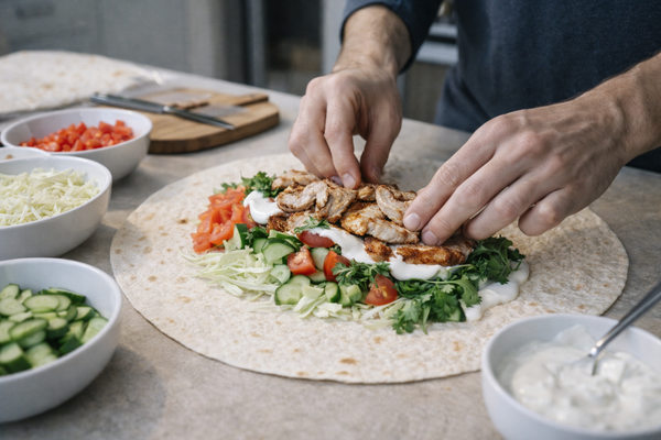 Процесс приготовления домашней шаурмы с курицей и свежими овощами на кухне