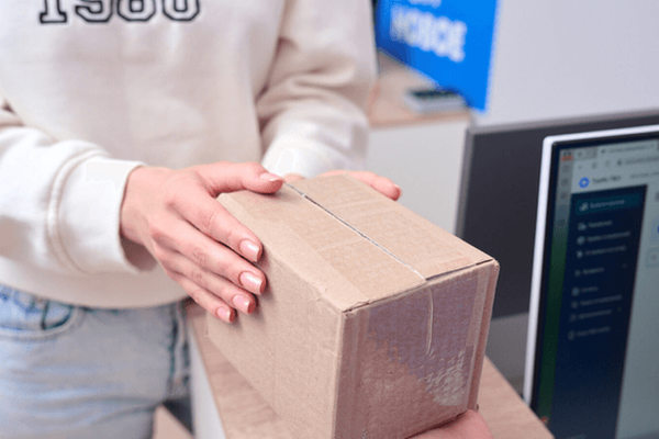 Сотрудник пункта выдачи заказов за компьютером с уведомлением о подозрительной активности и блокировке доступа к кабинету