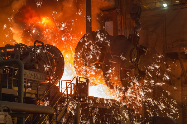 Производство стали в металлургическом цехе: выплавка жидкой стали и искры при разливке металла