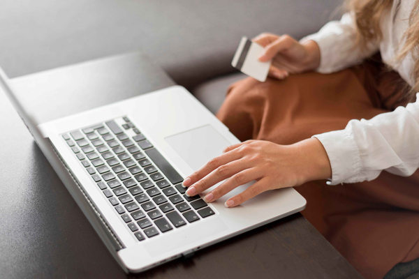 Женщина оплачивает покупку в интернет-магазине с ноутбука банковской картой — онлайн-платежи и рост e-commerce в России