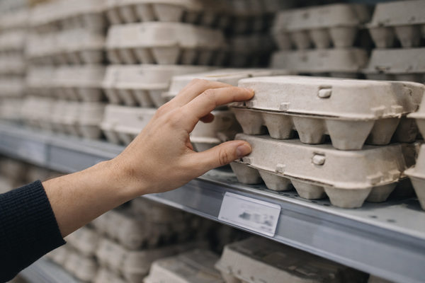 покупатель выбирает яйца на полке супермаркета рост цен перед пасхой и сезонный спрос