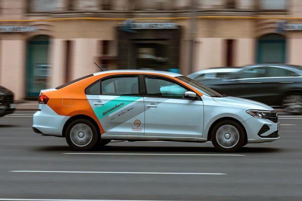 Автомобиль сервиса каршеринга Делимобиль на городской улице — иллюстрация к статье о финансовых результатах и экономике рынка каршеринга