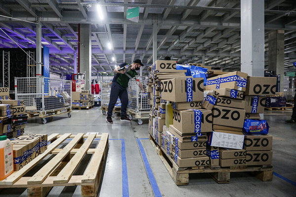 Складской комплекс Ozon с обработкой заказов и паллетами коробок — иллюстрация расширения логистической инфраструктуры до 5 млн кв. м