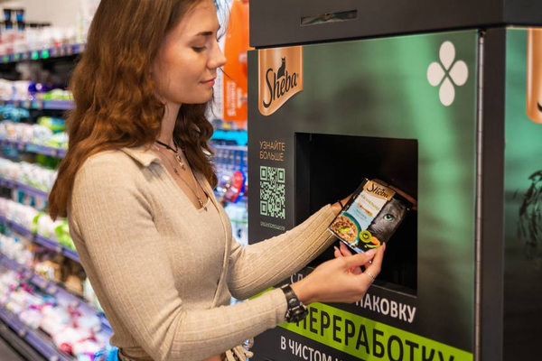 Покупатель сдаёт упаковку паучей для переработки в автомате в магазине «Перекрёсток»